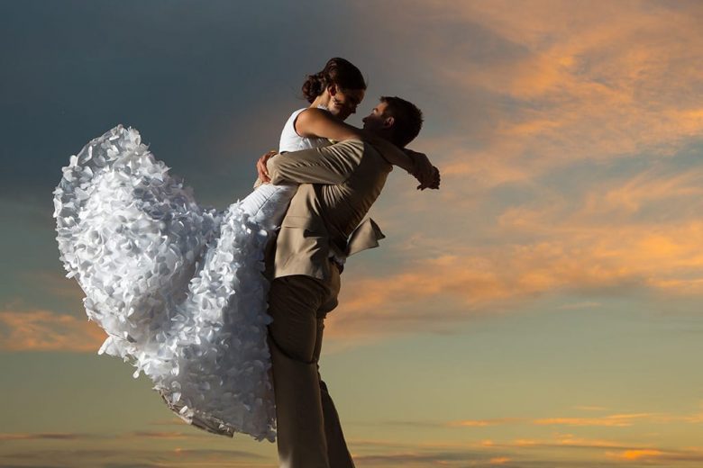 Couple embracing against a pretty sky at dusk