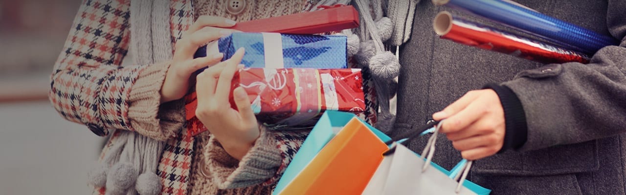 Couple holding presents and wrapping paper