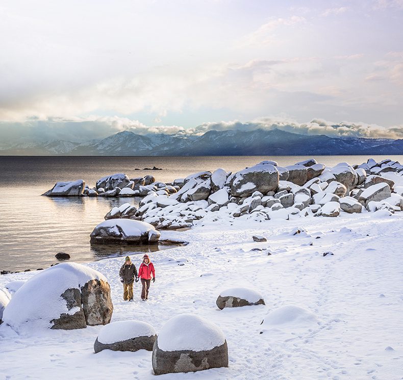 Couple walking in snow around Lake Tahoe in winter