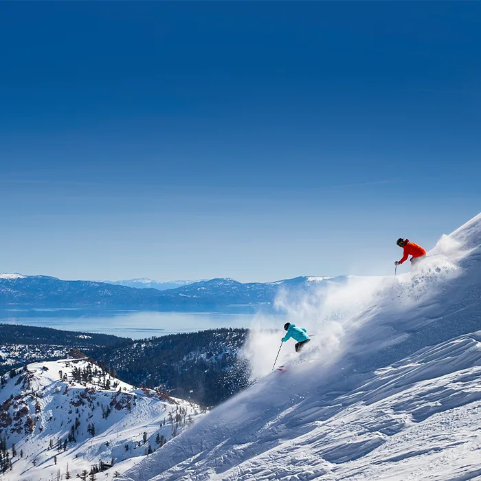 Two skiers skiing on the powdery slopes of Lake Tahoe
