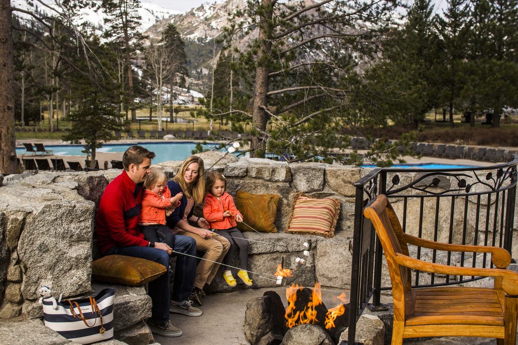Family making s'mores by a campfire