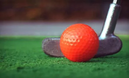 Orange golf on a putting green about to be putt
