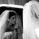 Bride putting on lipstick in the mirror on her wedding day