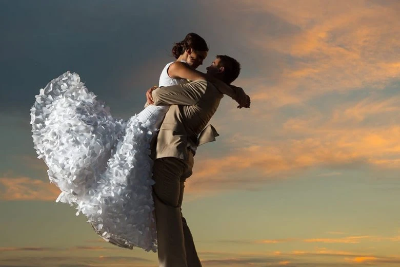 Couple embracing against a pretty sky at dusk