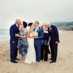 Wedding party on the beach of the Lake Tahoe kissing