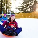 Mother and baby sledding in Lake Tahoe at Tahoe City's Winter Sports Park