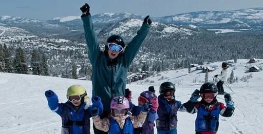 Family celebrating on the top of a snowy mountain