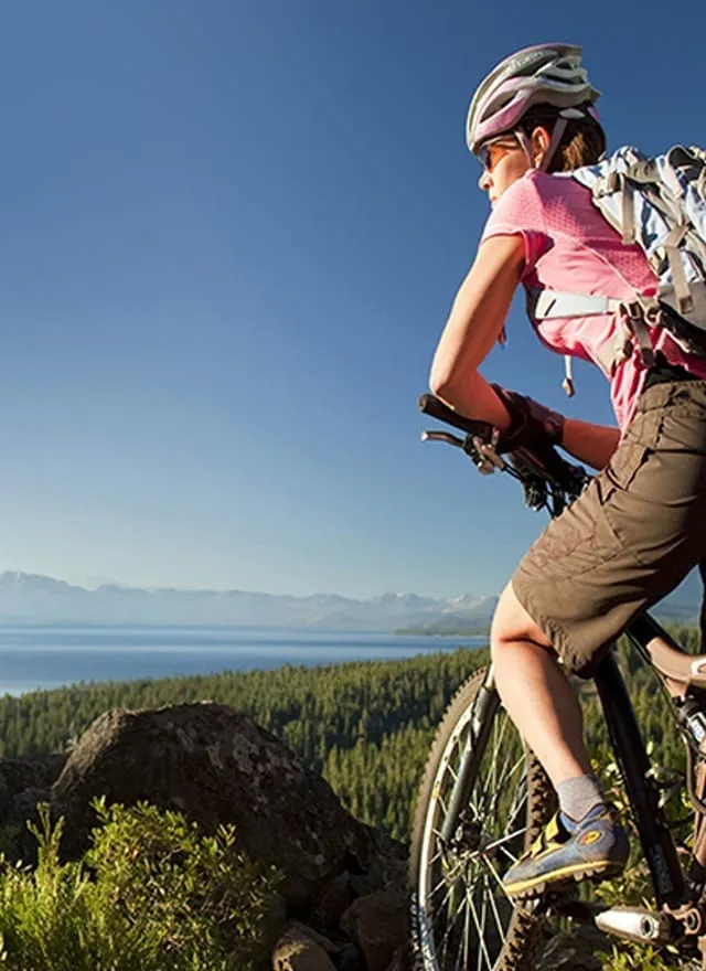 Woman resting on her bike at an overlook