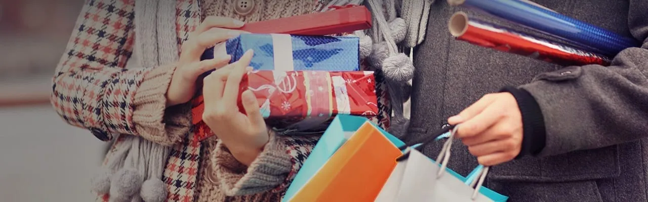 Couple holding presents and wrapping paper