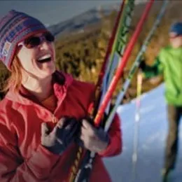 Woman laughing while holding skis