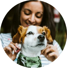 Closeup of smiling dog with woman behind