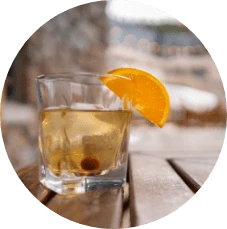 Cocktail wit orange slice placed on railing outside