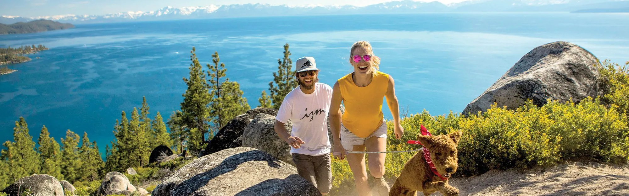 Couple hiking up a trail with their dog in Lake Tahoe