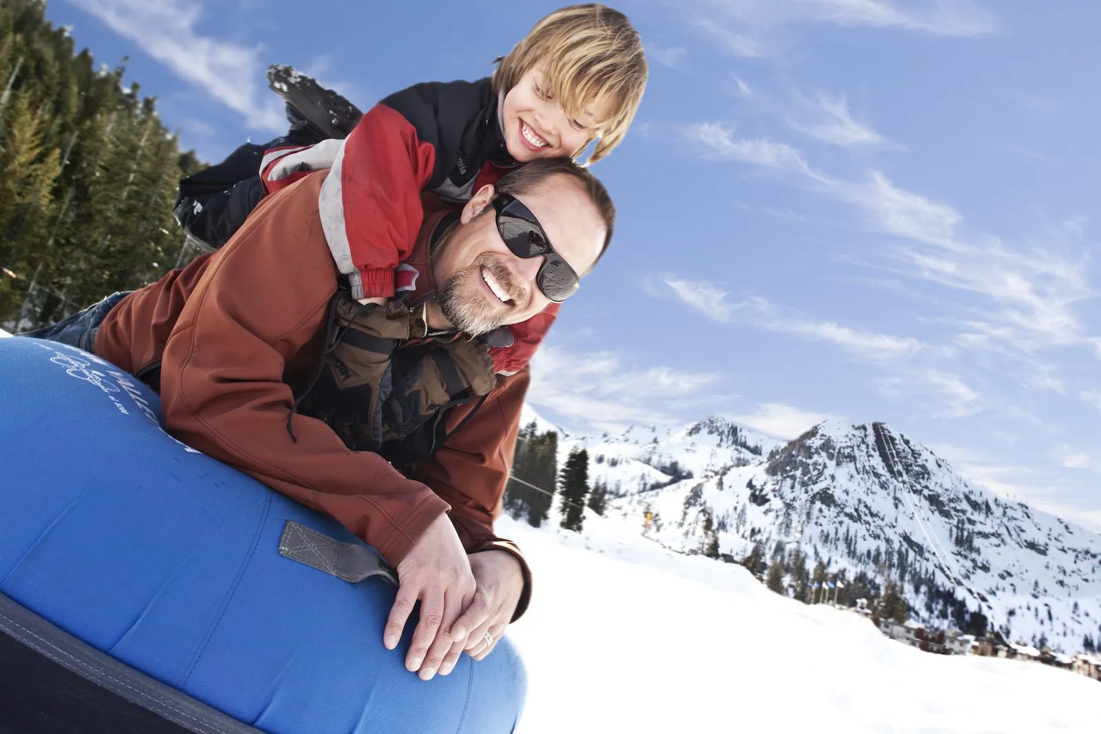 Father and son riding on a tube down a slope in Lake Tahoe 