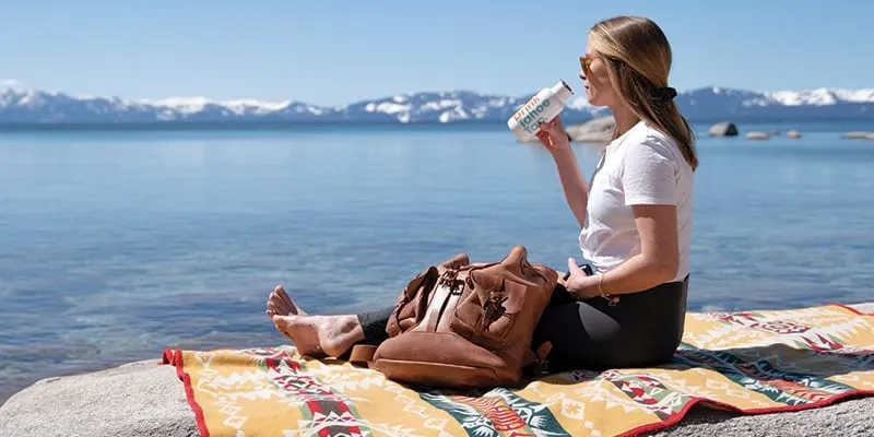 Woman enjoying a beverage on the shores of Lake Tahoe