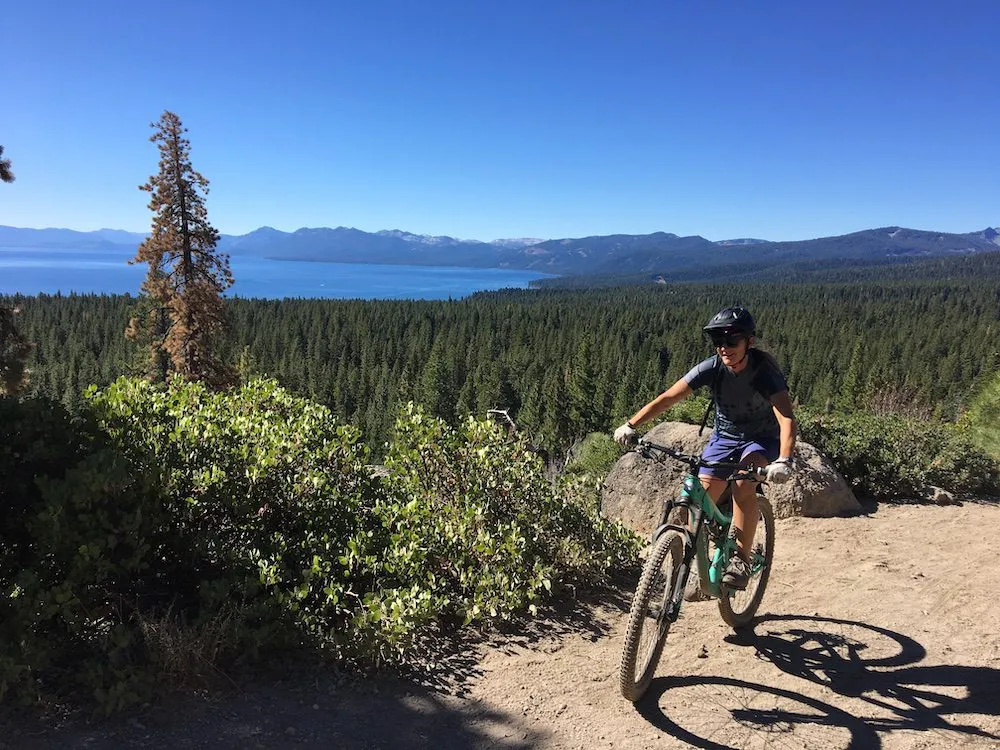 Woman riding mountain bike on a path overlooking Lake Tahoe 
