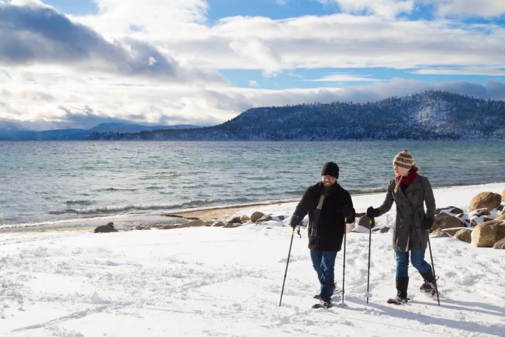 People snowshoeing on the shore of Lake tahoe