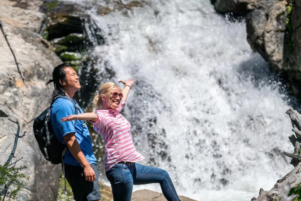 Couple standing next to a waterfall on a hike in Lake tahoe