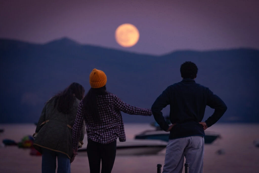 Friends looking at the full moon over Lake Tahoe
