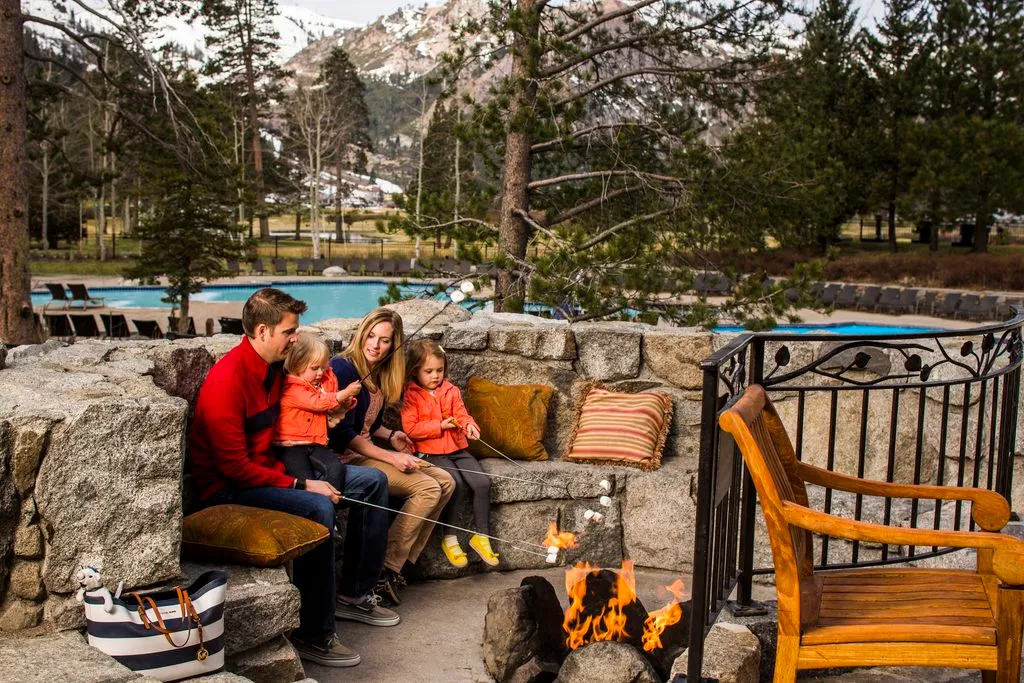 Family making s'mores by a campfire